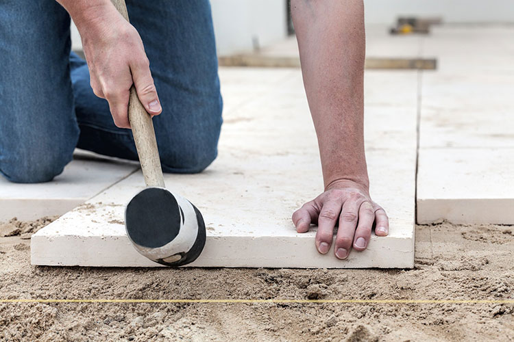 Man setting paver in place